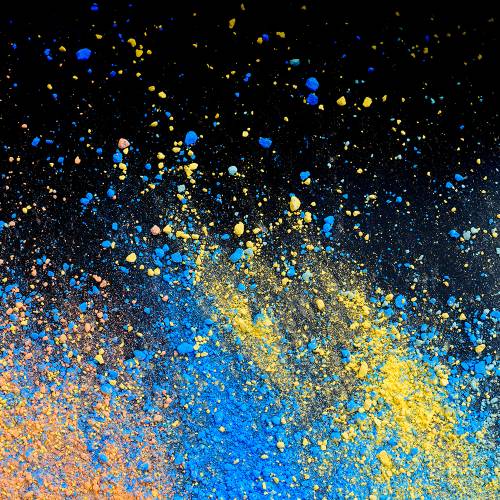 A splatter of pastel natural colored pigment powder on black background.